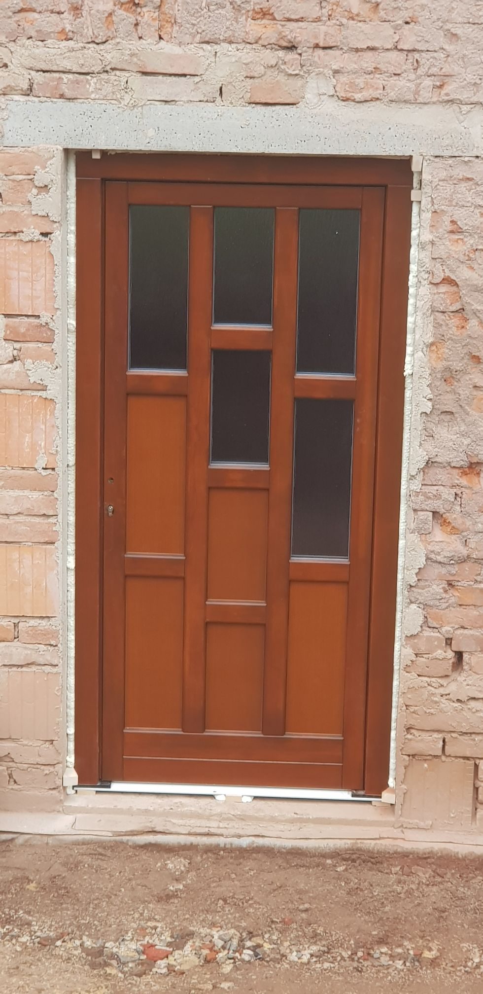 Dřevěné prosklené vstupní dveře v cihlovém ostění